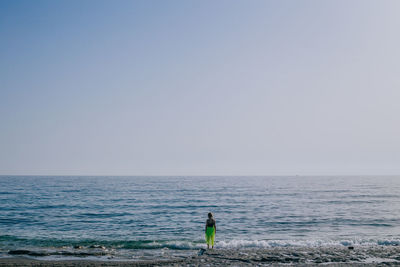 Rear view of man against sea against clear sky