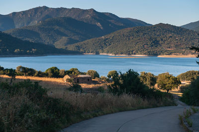 Scenic view of lake by mountains against sky