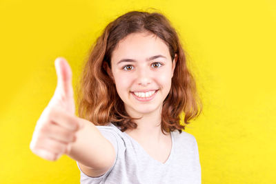 Portrait of smiling woman against yellow background