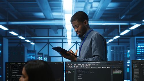 Side view of young man using mobile phone in office