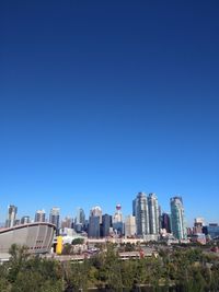 Buildings in city against clear blue sky