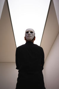 Low angle view of man standing against wall