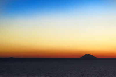 Scenic view of sea against orange sky