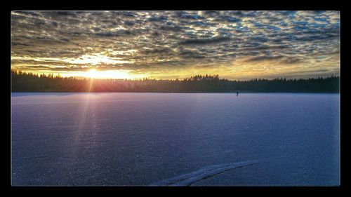 Snow covered landscape at sunset