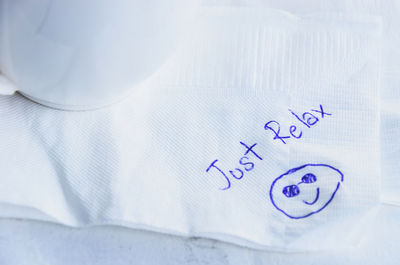 High angle view of text with smiley face on tissue paper