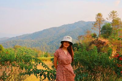 Portrait of woman standing against plants