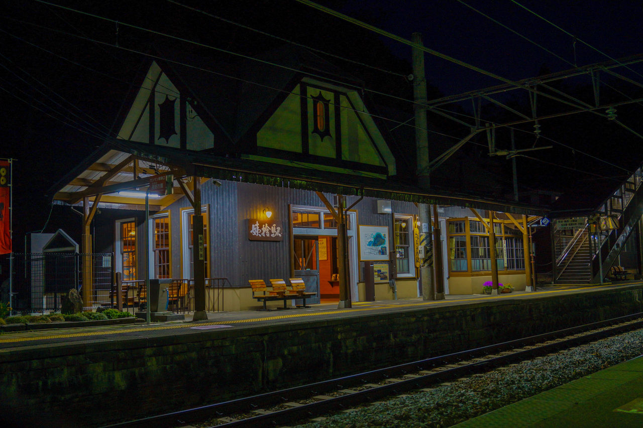 rail transportation, track, railroad track, night, transportation, architecture, train station, train, mode of transportation, railroad station, illuminated, built structure, transport, public transportation, metropolitan area, railroad station platform, vehicle, no people, travel, building exterior, railway, evening, nature, rolling stock, outdoors, city