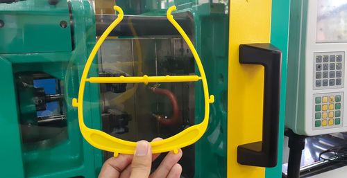 Person holding yellow machine in car