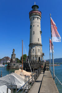 View of lighthouse by sea against clear sky