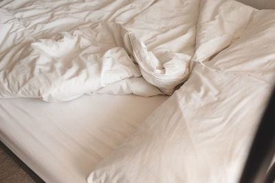 Hotel room bedroom with white pillows and blanket with duvet top view. selective focus.