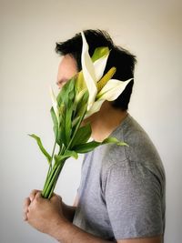 Midsection of person holding rose against white background