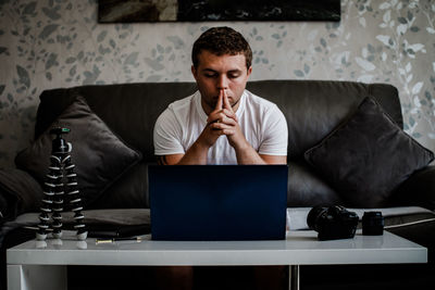 Mid adult man using mobile phone while sitting on table