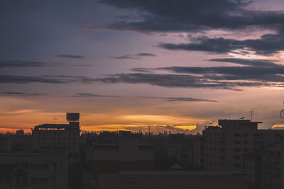 Silhouette buildings against sky at sunset