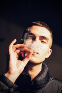 Portrait of young model man smoking cigarette