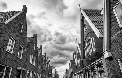 Low angle view of buildings against cloudy sky