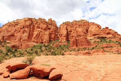 Rock formations on mountain against cloudy sky