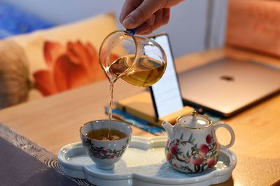 Midsection of woman holding coffee on table