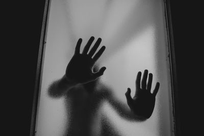 Shadow of woman hand on glass window