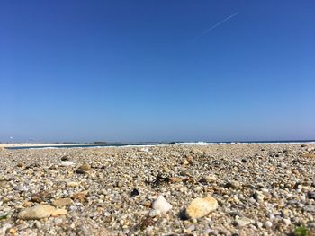 Scenic view of beach against clear blue sky