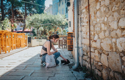 Man with dog sitting in front of building