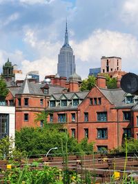 Buildings in city against cloudy sky