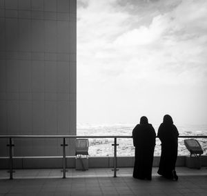 Rear view of people looking at sea against sky