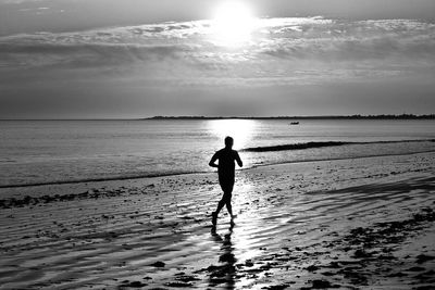 Silhouette man on beach against sky