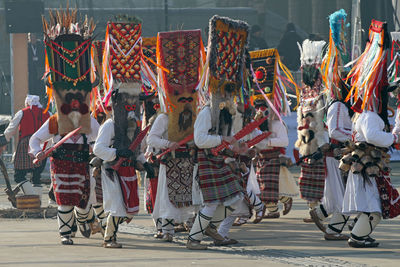 Men in traditional clothing dancing on road