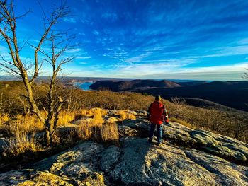 Rear view of man on mountain against sky