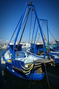 Ship moored in sea against clear blue sky