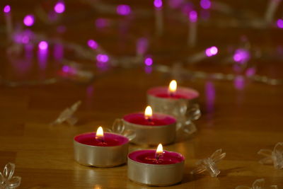 Close-up of burning candles on wooden table during christmas