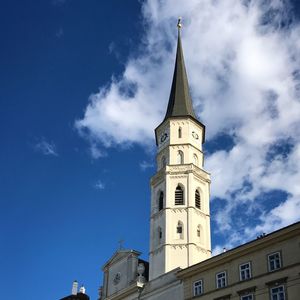 Low angle view of clock tower amidst buildings against sky