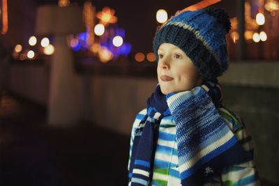 Boy in warm cloth standing outdoors at night