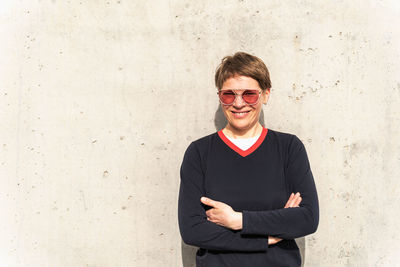 Portrait of young man standing against wall