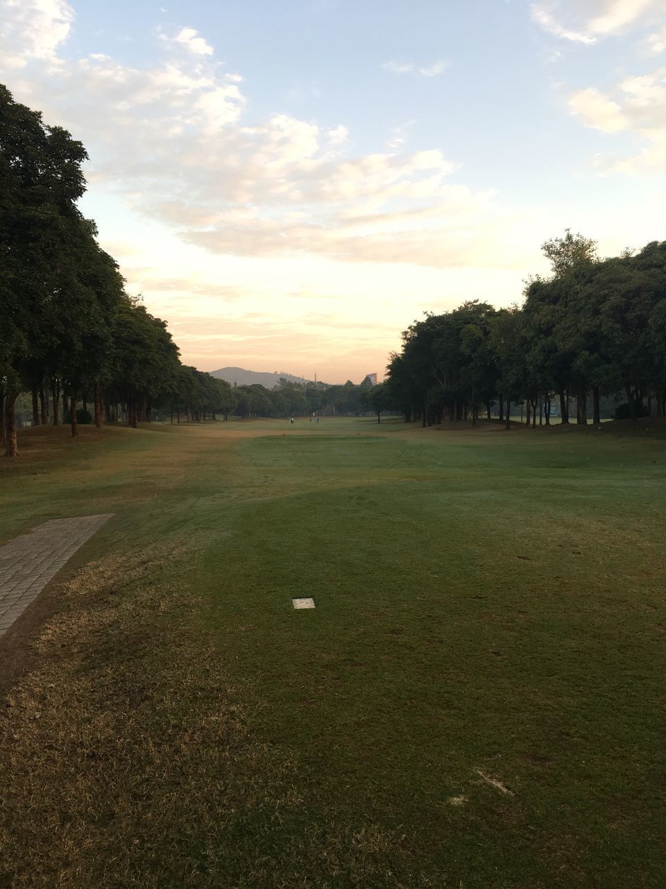 SCENIC VIEW OF GOLF COURSE AGAINST SKY DURING SUNSET