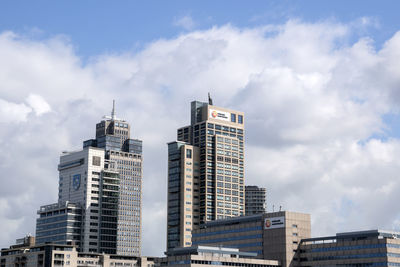 Low angle view of buildings against cloudy sky