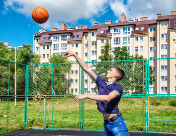 Young man playing basketball in court