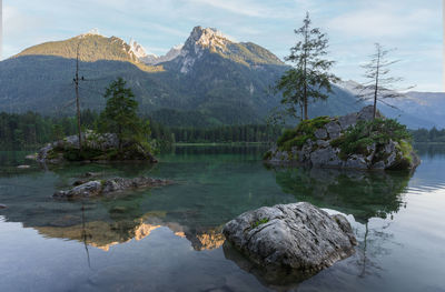 Crystal clear alpine tarn with rocky islands scene during sunrise, hintersee, germany