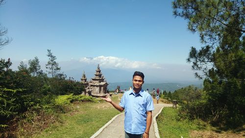 Portrait of young man standing against temple