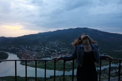 Woman at observation point against mountain in town