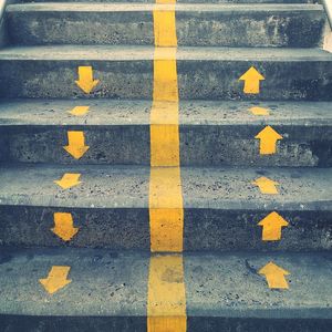 High angle view of yellow arrow symbol on road