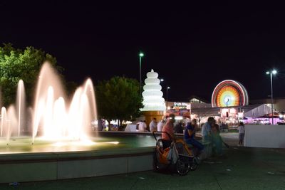 Man in fountain at night