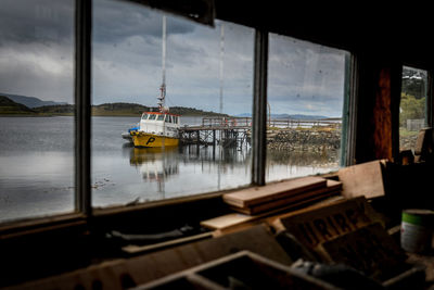 Sailboats in sea seen through window