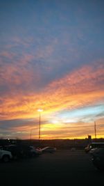 Cars on road against sky during sunset