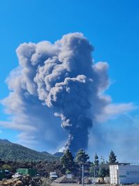 Smoke emitting from chimney against sky