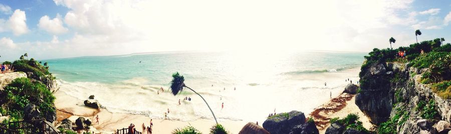 Panoramic view of people on beach against sky