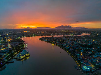 High angle view of illuminated city at sunset