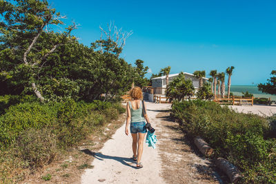 Rear view of woman walking on road