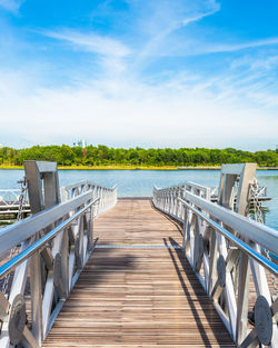 Empty pier over lake against sky