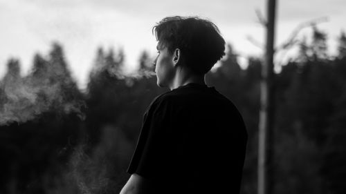 Rear view of man standing against trees